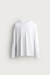 Camiseta slim fit blanca de manga larga y cuello redondo, confeccionada en tejido de algodón con elasticidad.