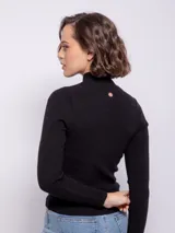 Polera de tejido de punto con diseño de textura tramada y pequeños puntos calados, de corte ajustado al cuerpo y cuello alto.