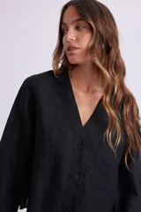 Camisa negra de lino con cuello en V y cierre frontal con botones.