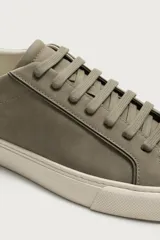 Zapatilla de estilo minimalista con cordones, confeccionada en material sintético de acabado mate. Presenta una horma redonda, forro interior en tono contrastante y suela de goma con textura ligera.