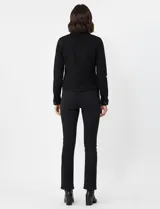 Campera de jean color negro, con cuello solapa, cierre frontal con botones metálicos y bolsillos aplicados en el frente.