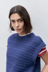 Chaleco tejido azul de calce relajado, silueta recta, cuello redondo, hombros caídos y diseño de punto con textura calada.