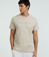 Remera de algodón color beige, de corte comfort con cuello redondo y manga corta. Presenta estampa frontal localizada con texto "NAUTIC CLUB" y un logotipo de velero.