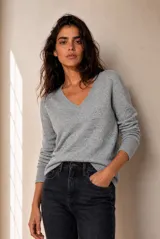 Sweater de punto melange gris con escote en V y mangas largas.