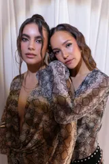 Vestido corto confeccionado en tul y lycra con estampado animal print de serpiente, escote en V pronunciado y mangas largas con diseño acampanado.