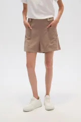 Short de lino color beige, de tiro alto y corte holgado. Presenta bolsillos frontales amplios y detalle de botones decorativos en la cintura.