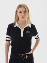 Remera tejida tipo polo, color rojo, con cuello azul marino y rayas blancas. Tiene botones frontales, largo cropped y mangas cortas con franjas azules.