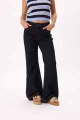 Pantalón jean de denim azul oscuro, corte wide leg, tiro medio y costuras a la vista en color ocre.