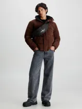 Riñonera negra Calvin Klein Jeans con logo estampado en el frente y correa ajustable.