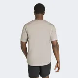 Remera Adidas Workout Essentials Feelready de color gris melange, con diseño clásico de manga corta y cuello redondo. Cuenta con el logo de la marca estampado en el pecho en color negro y tecnología de absorción de humedad.