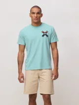 Remera de algodón orgánico color blanco, con corte regular fit y detalle de bordado en forma de X con diseño geométrico multicolor en el pecho.