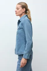 Camisa de jean de corte recto y calce relajado, con cuello clásico, cierre frontal con botones metálicos y dos bolsillos frontales con solapa.