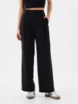 Pantalón de vestir negro de corte recto y tiro alto, con pinzas frontales y bolsillos laterales.