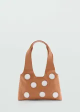 Bolso tipo tote de cuero color marrón claro con apliques de espejos blancos cosidos.