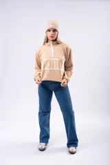 Buzo oversize de algodón color beige, con cuello polo y cierre frontal parcial. Presenta una franja horizontal blanca en el pecho con el texto 'SOHO' estampado en color beige.