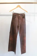 Pantalón de cuero napa color marrón con efecto envejecido, corte recto y trabillas para cinturón.