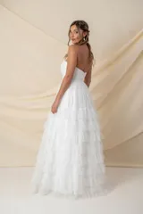 Vestido largo blanco de tul, estilo strapless con corsé drapeado en forma de corazón y falda amplia con múltiples volados.