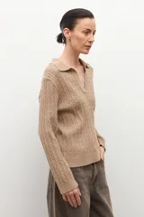 Sweater azul marino de tejido de punto con cuello polo y escote en V. Presenta un diseño de trenzas verticales en toda la prenda y mangas largas.