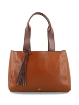 Cartera shopper de cuero color cognac con doble asa de hombro y detalle de borla colgante en el lateral.