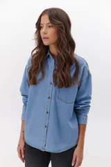 Camisa de jean celeste con botones metálicos envejecidos, manga larga y bolsillo en el pecho.
