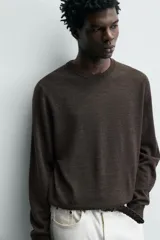 Sweater de punto regular fit fabricado en lana, color gris oscuro, con cuello redondo y manga larga. Cuenta con puños y cintura acanalados.