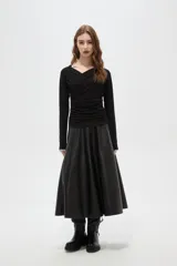 Top de manga larga color negro, confeccionado en poliéster, con diseño drapeado frontal y cuello en V.