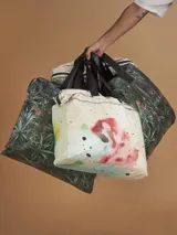 Bolso tote reutilizable de tela Tyvek con estampado abstracto en tonos verdes y negros. Asas de cinta gross negra con inscripción "THOMAS".