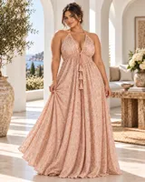 Vestido largo rosado con escote en V halter, tirantes finos y falda fluida amplia. Presenta bordados artesanales a mano con detalles brillantes en toda la prenda y cordón frontal ajustable con borlas.