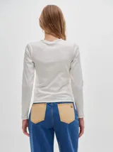 Remera de manga larga con cuello a la base, confeccionada en tejido acanalado con calce al cuerpo y diseño tipo crop.