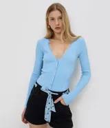 Short de jean negro de tiro alto con bolsillos delanteros y traseros, cierre con botón y cremallera, e incluye un pañuelo celeste con lunares y ojales metálicos para usar como lazo en la cintura.