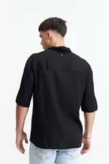 Camisa blanca de manga corta, corte oversize y cuello clásico.