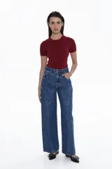 Jean de tiro alto, pierna recta y ancho, color azul medio. Presenta costuras decorativas en forma de V invertida que recorren el frente de ambas piernas.