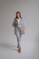 Campera de gabardina color celeste, con capucha, cierre frontal completo y mangas tres cuartos con detalle de trabilla.