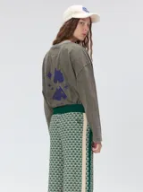 Pantalón de punto jacquard con diseño geométrico texturizado, de corte holgado y pierna ancha. Presenta tiro medio, cintura elástica con cordón ajustable y aberturas laterales en el ruedo.