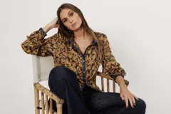 Camisa de seda con estampado de flores tipo hippie en colores mostaza, verdes y ocre con botones símil metal y cuello clásico.