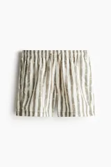 Short de baño con diseño de rayas verticales irregulares en tonos beige y marrón. Cuenta con cintura elástica con cordón de ajuste, bolsillos laterales y un bolsillo trasero con cierre autoadherente. Presenta aberturas laterales en el ruedo y suspensor interior de malla.