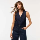 Chaleco de traje confeccionado en tejido denim de color azul oscuro, con escote en V, cierre frontal mediante botones y corte entallado.