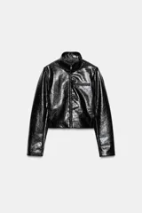 Chaqueta corta de efecto piel con acabado brillante y textura arrugada. Presenta cuello subido, cierre frontal con cremallera, mangas largas y bolsillos ocultos en las costuras delanteras.
