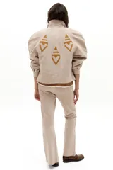 Pantalón de gamuza beige de corte recto, con tiro medio y elástico interno.