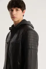 Campera de cuero sintético negra con capucha de algodón gris, cierre frontal con cremallera, bolsillos laterales con cremallera y detalles acolchados en hombros y mangas.