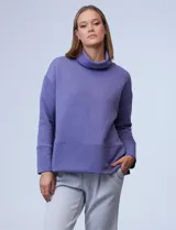 Buzo de jersey color lila con cuello alto y tajos laterales.