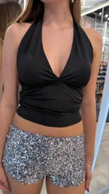 Top negro con escote halter profundo y diseño ajustado.