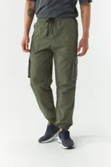 Pantalón cargo gris de nylon con cintura ajustable, bolsillos laterales con solapa y puños elásticos.