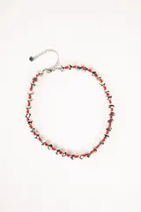 Collar corto de cadena plateada con eslabones pequeños y cuentas irregulares plateadas intercaladas con cuentas pequeñas negras.