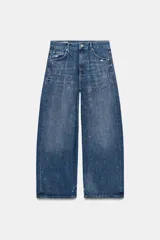 Jeans baggy de tiro medio con cinco bolsillos, trabillas para cinto y cierre frontal con cremallera y botón metálico. Cuenta con detalle de aplicación de brillos en toda la prenda.