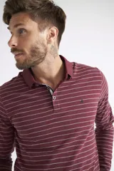Polo de manga larga para hombre, con diseño a rayas horizontales blancas sobre fondo azul marino. Presenta cuello clásico, cierre frontal con botones y logo bordado en el pecho.