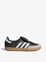 Zapatillas Adidas Samba LT, color negro con las tres tiras blancas y suela de goma marrón.