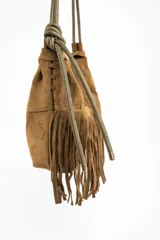 Cartera de hombro con diseño de flecos largos en la parte frontal, confeccionada en material sintético con textura de gamuza. Cuenta con una correa larga ajustable y cierre superior.