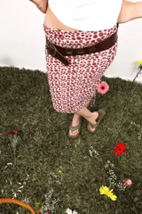 Faja de cuero marrón con diseño de tiras verticales metálicas decorativas y cierre de hebilla frontal.