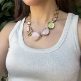 Collar dorado con cadena de eslabones circulares y dije con piedras de colores rosa y verde agua.